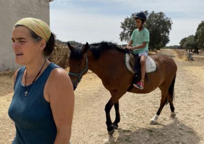 Niño montado a caballo con acompañante en Granja escuela Las Cortas de Blas